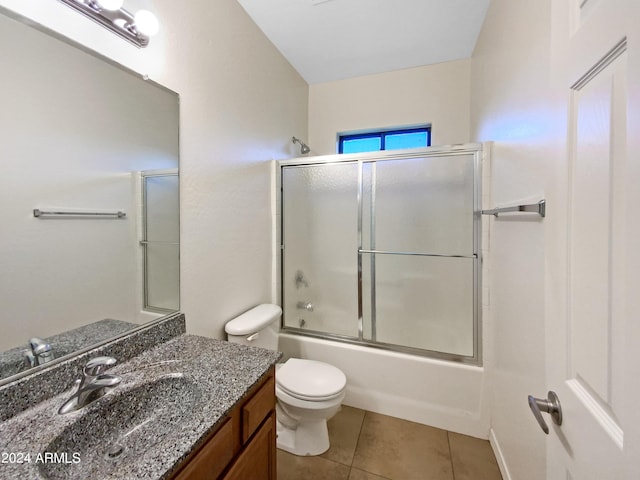 full bath with tile patterned flooring, toilet, vanity, and shower / bath combination with glass door