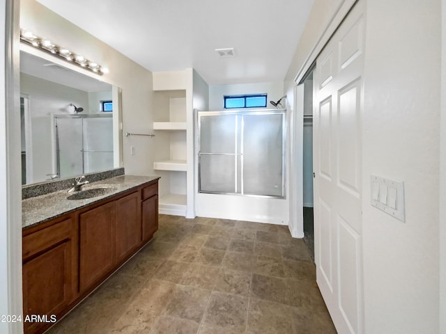 bathroom with vanity, visible vents, and a shower with shower door