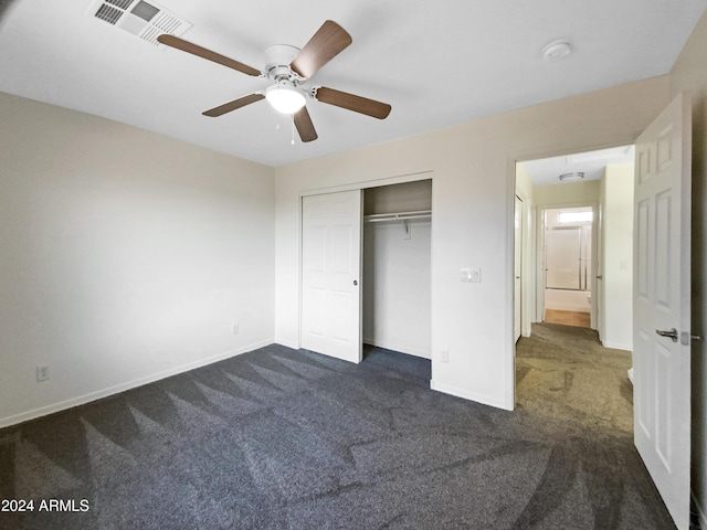 unfurnished bedroom featuring a closet, visible vents, dark carpet, and baseboards