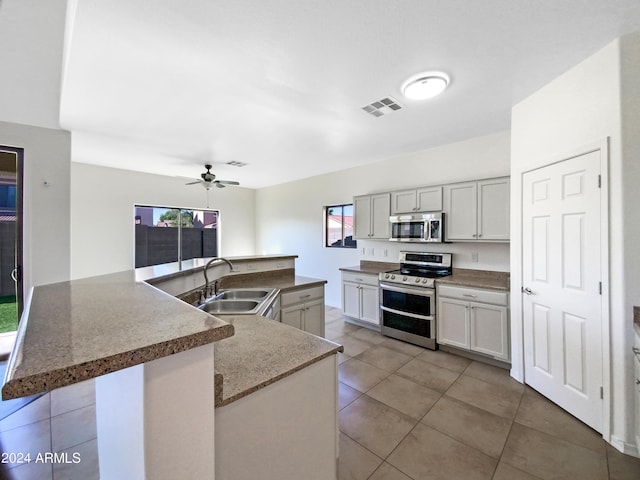 kitchen featuring visible vents, light tile patterned flooring, stainless steel appliances, a ceiling fan, and a sink