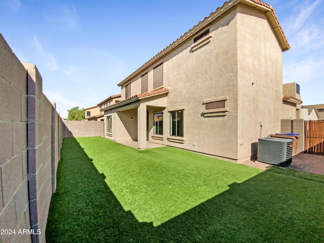 back of property featuring stucco siding, a lawn, a fenced backyard, and a tile roof