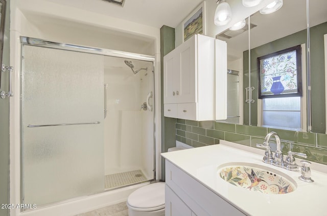 bathroom with toilet, a shower with shower door, tasteful backsplash, and vanity