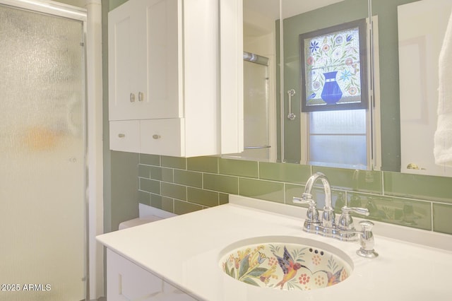 bathroom featuring a shower with door, decorative backsplash, and sink