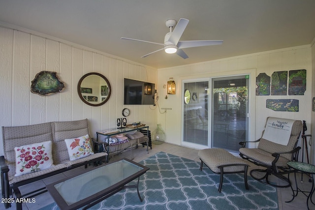 living room featuring ceiling fan, crown molding, and wooden walls