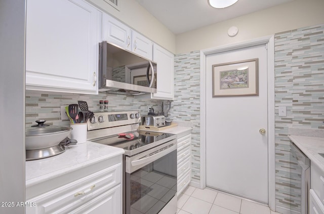 kitchen with backsplash, white cabinets, stainless steel appliances, and light tile patterned flooring