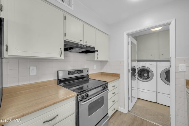 kitchen with washer and dryer, light countertops, stainless steel electric range, and under cabinet range hood