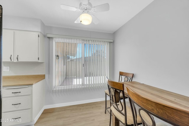 dining space featuring light wood-style flooring, baseboards, and ceiling fan