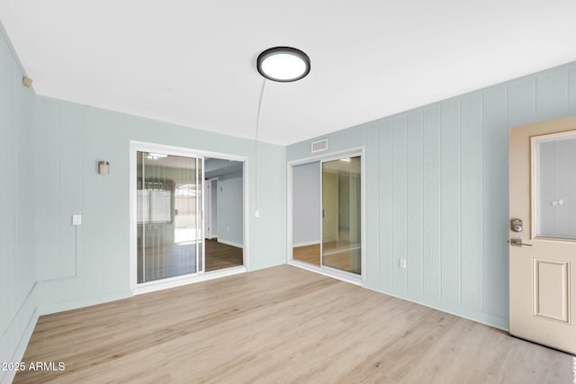 unfurnished room featuring visible vents and wood finished floors