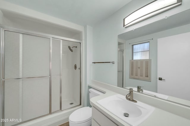 bathroom with vanity, toilet, and a stall shower