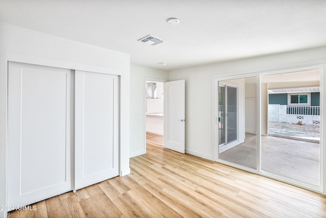 unfurnished bedroom with access to exterior, light hardwood / wood-style floors, and a closet