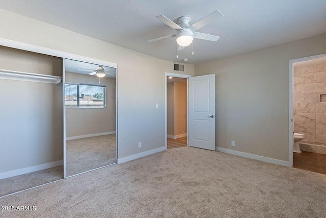 unfurnished bedroom with visible vents, a closet, ensuite bath, and carpet flooring