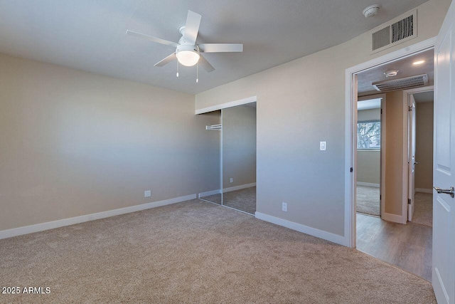 unfurnished bedroom with visible vents, a closet, carpet, baseboards, and ceiling fan