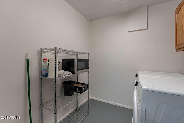 laundry room with baseboards, cabinet space, and washer and clothes dryer