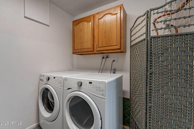 washroom with cabinet space and washer and clothes dryer