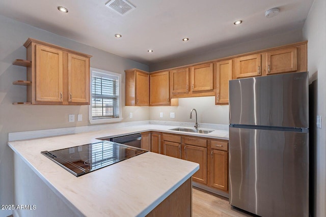 kitchen featuring visible vents, a sink, appliances with stainless steel finishes, a peninsula, and open shelves