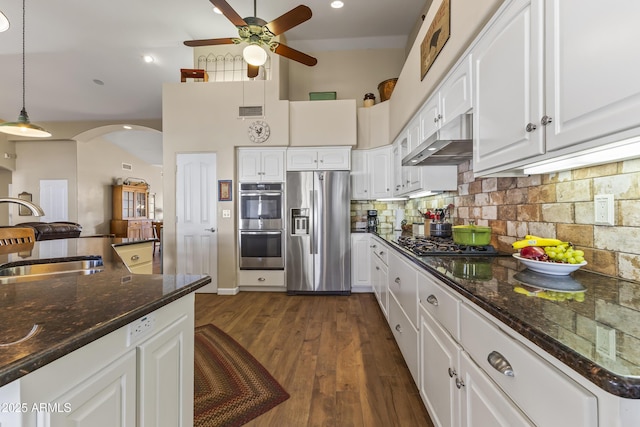 kitchen with appliances with stainless steel finishes, sink, dark stone countertops, white cabinets, and hanging light fixtures