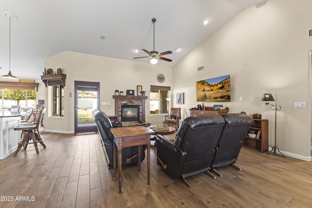 living room featuring wood-type flooring, high vaulted ceiling, and ceiling fan