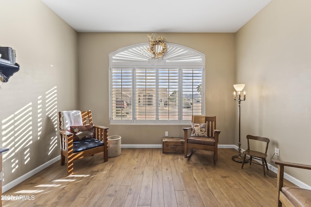 living area with an inviting chandelier and light hardwood / wood-style flooring