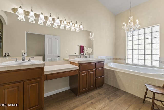 bathroom featuring vanity, hardwood / wood-style floors, and tiled tub