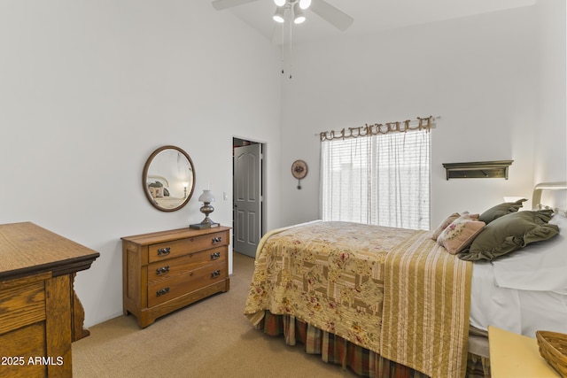 carpeted bedroom with ceiling fan and a high ceiling