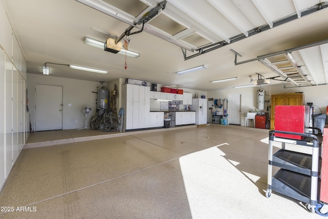 garage featuring a garage door opener, white refrigerator with ice dispenser, and water heater