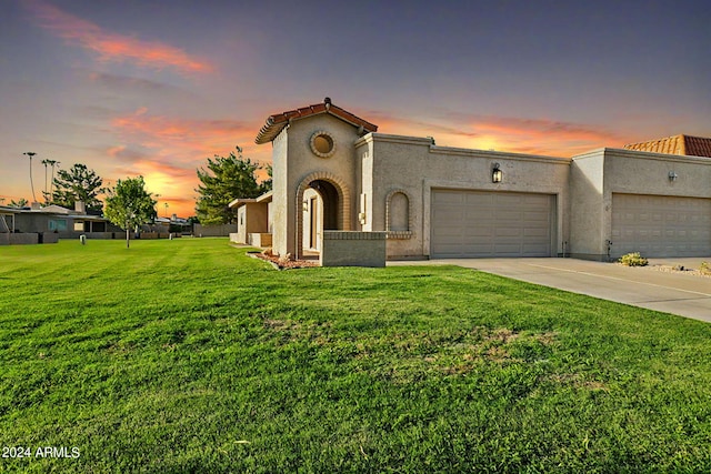 mediterranean / spanish home featuring a garage, a front yard, stucco siding, and a tile roof