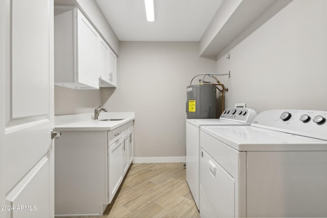 clothes washing area with water heater, separate washer and dryer, light wood-style floors, cabinet space, and a sink