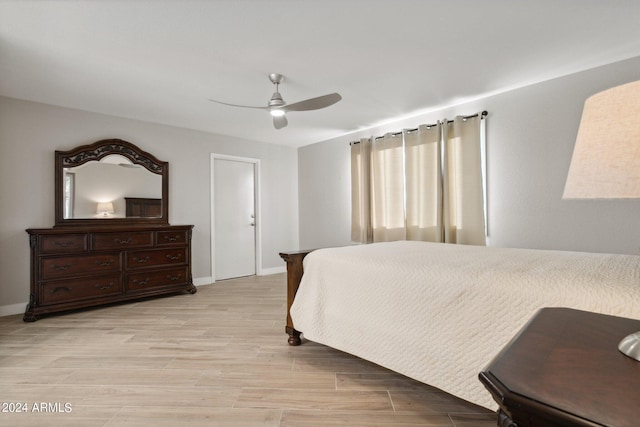 bedroom with light wood-style floors, baseboards, and ceiling fan