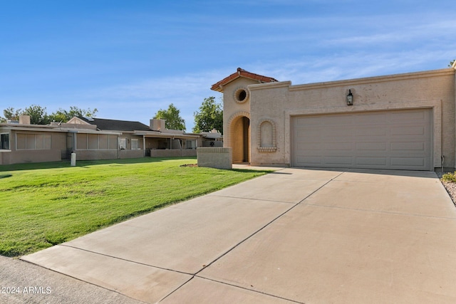 mediterranean / spanish home featuring driveway, stucco siding, a front lawn, a garage, and a tiled roof