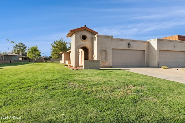 mediterranean / spanish home featuring a tile roof, a front yard, stucco siding, driveway, and an attached garage