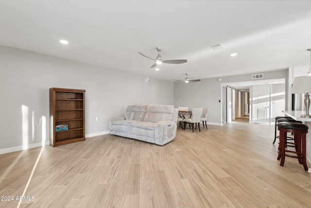 sitting room with visible vents, baseboards, light wood-type flooring, and ceiling fan