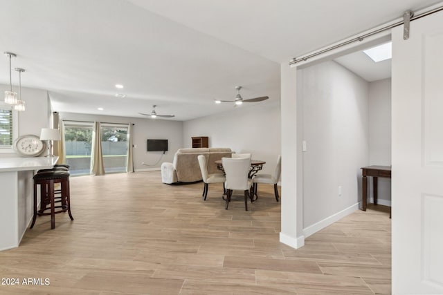 living room featuring light wood-style flooring, baseboards, and ceiling fan