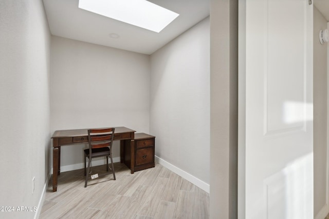 office with a skylight and light hardwood / wood-style flooring