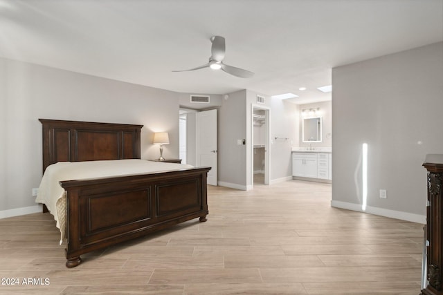 bedroom featuring light hardwood / wood-style flooring, ensuite bathroom, and ceiling fan