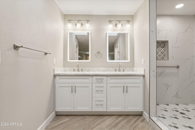 bathroom with hardwood / wood-style floors, a tile shower, and vanity