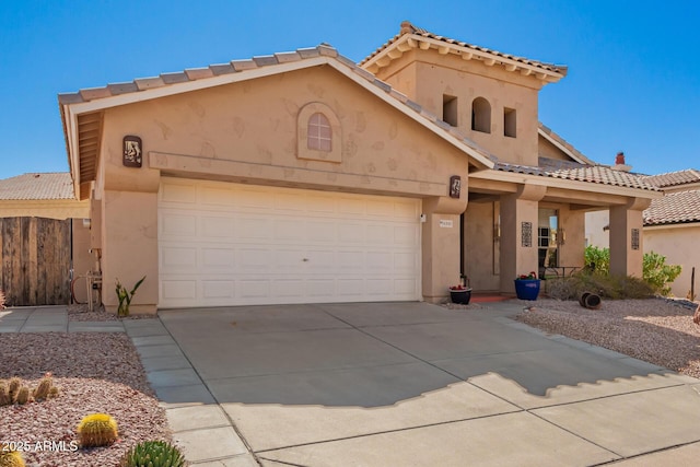 mediterranean / spanish-style home featuring a garage, fence, driveway, a tiled roof, and stucco siding