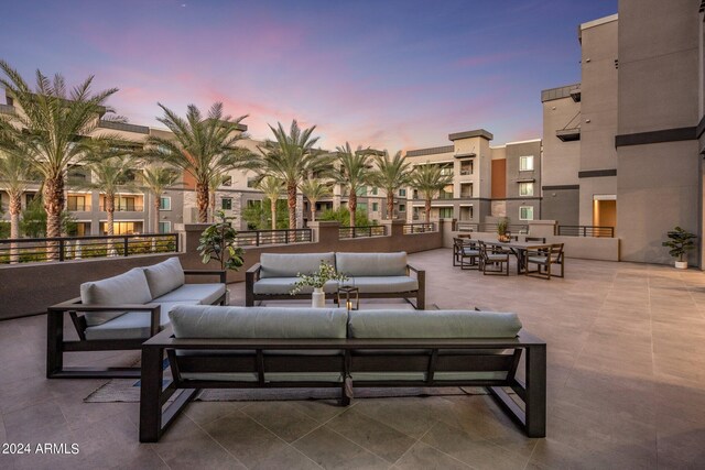 patio terrace at dusk with a balcony and outdoor lounge area