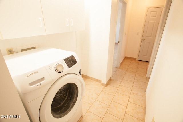 washroom featuring light tile patterned floors, washer / dryer, and cabinets