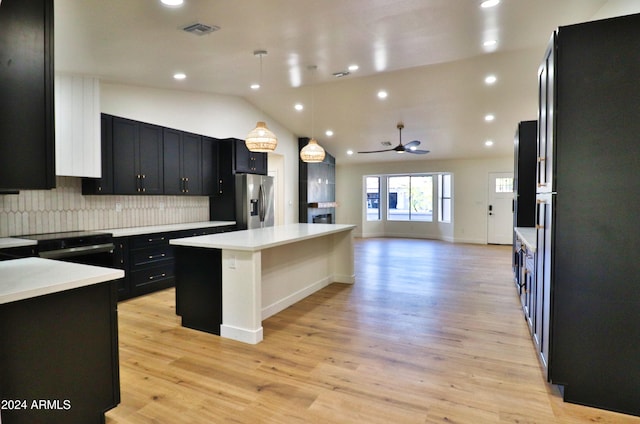 kitchen featuring hanging light fixtures, a kitchen island, vaulted ceiling, light hardwood / wood-style floors, and stainless steel refrigerator with ice dispenser