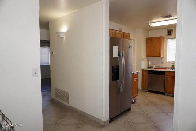 1670 W Bitter Orange St, Tucson, AZ 85705 - kitchen featuring appliances with stainless steel finishes, light countertops, light tile patterned flooring, and brown cabinets