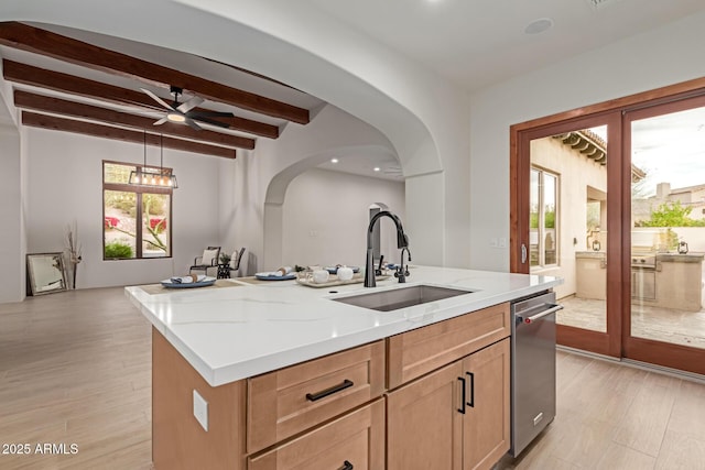 kitchen with ceiling fan, sink, beam ceiling, dishwasher, and an island with sink