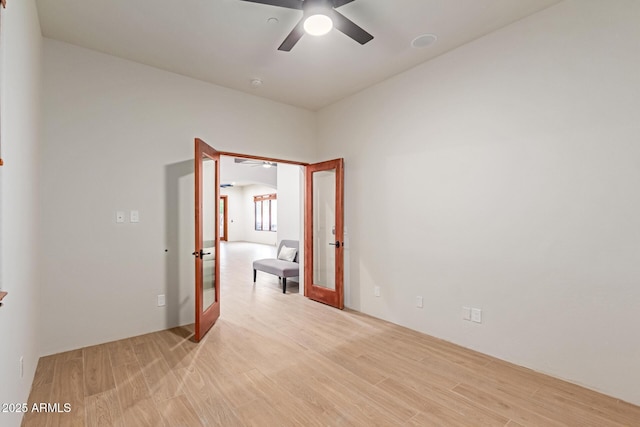 empty room featuring french doors, light hardwood / wood-style floors, and ceiling fan