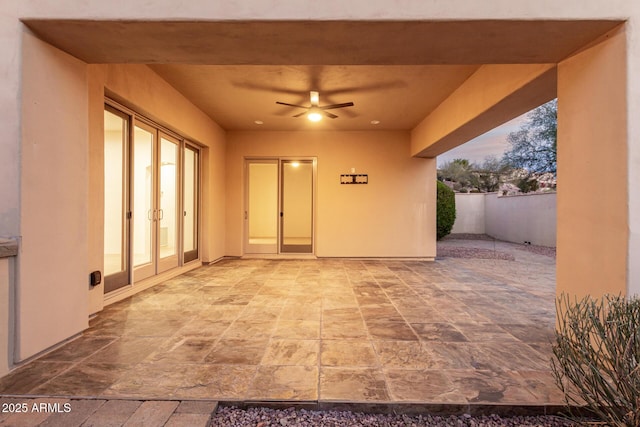 patio terrace at dusk featuring ceiling fan