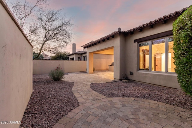 yard at dusk featuring a patio