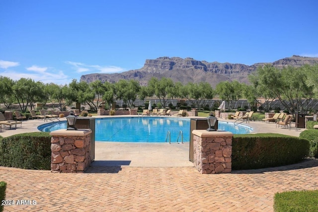 view of swimming pool featuring a mountain view and a patio