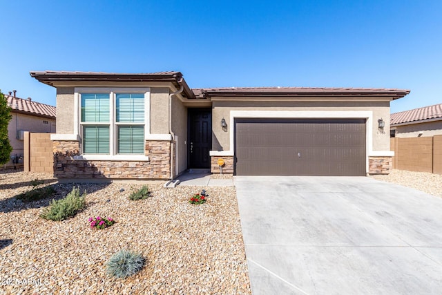 prairie-style house featuring a garage, stone siding, driveway, and stucco siding