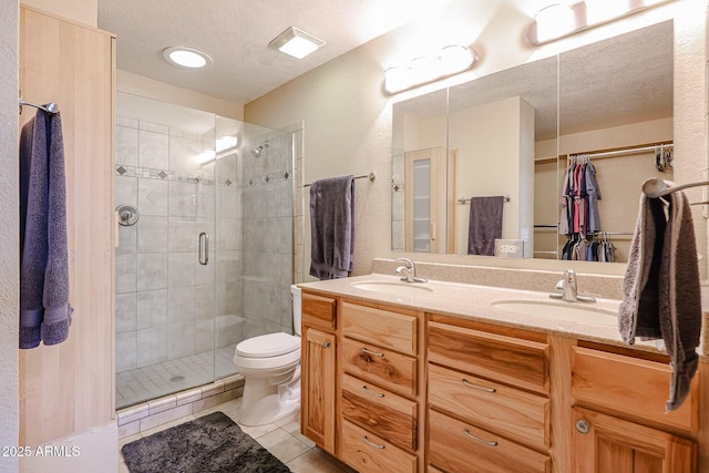 bathroom featuring toilet, an enclosed shower, a textured ceiling, tile patterned floors, and vanity