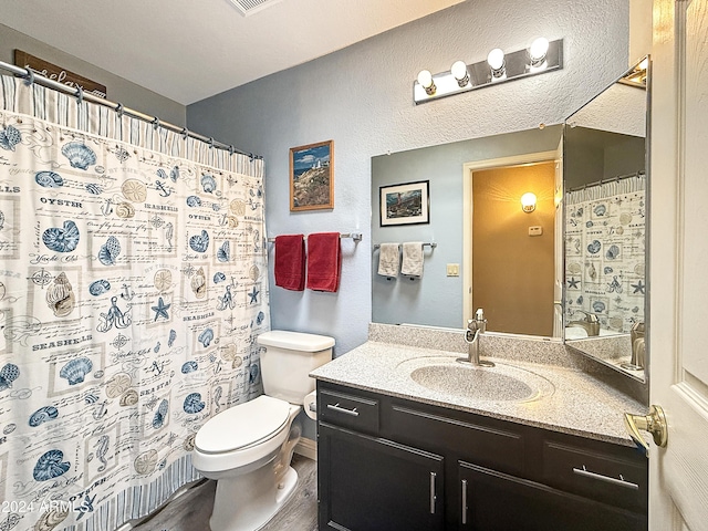 bathroom featuring walk in shower, vanity, wood-type flooring, and toilet