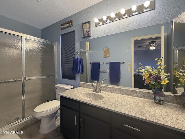 bathroom with vanity, a textured ceiling, ceiling fan, hardwood / wood-style floors, and toilet