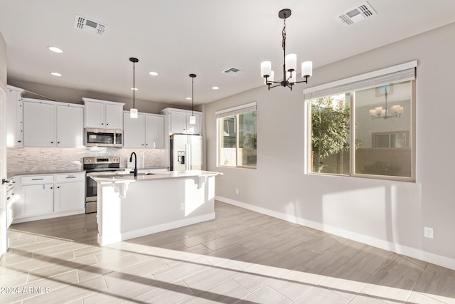 kitchen featuring white cabinetry, a kitchen island with sink, and stainless steel appliances